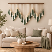 Beaded tassel wall hanging in a wave shape above a cream sofa