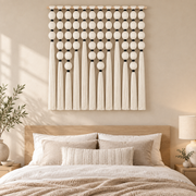 Cream sphere grid wall hanging centered above a wooden bedroom headboard