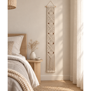 Cream macrame banner hung on the wall beside a bed in a nordic bedroom