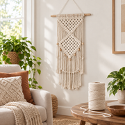 Finished macrame wall hanging in a living room with a spool on the side table