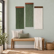 Three fringe panels above a woven bench in an apartment entryway