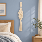 Bedroom on a blue wall beside a bed, plaited rope column in cream