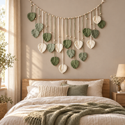 Sage and cream leaf garland above a made double bed beside a bright window