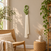 Boho sitting nook beside a rattan chair, rope knot with a cream tassel