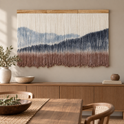 Dip dye mountain wall hanging above a fluted wooden sideboard in a dining room