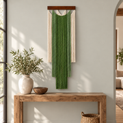 Green stepped fringe wall hanging above a rustic wooden entry console