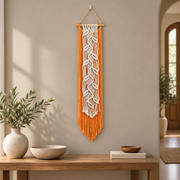 Orange macrame leaf banner above a wooden console in a hotel style entry
