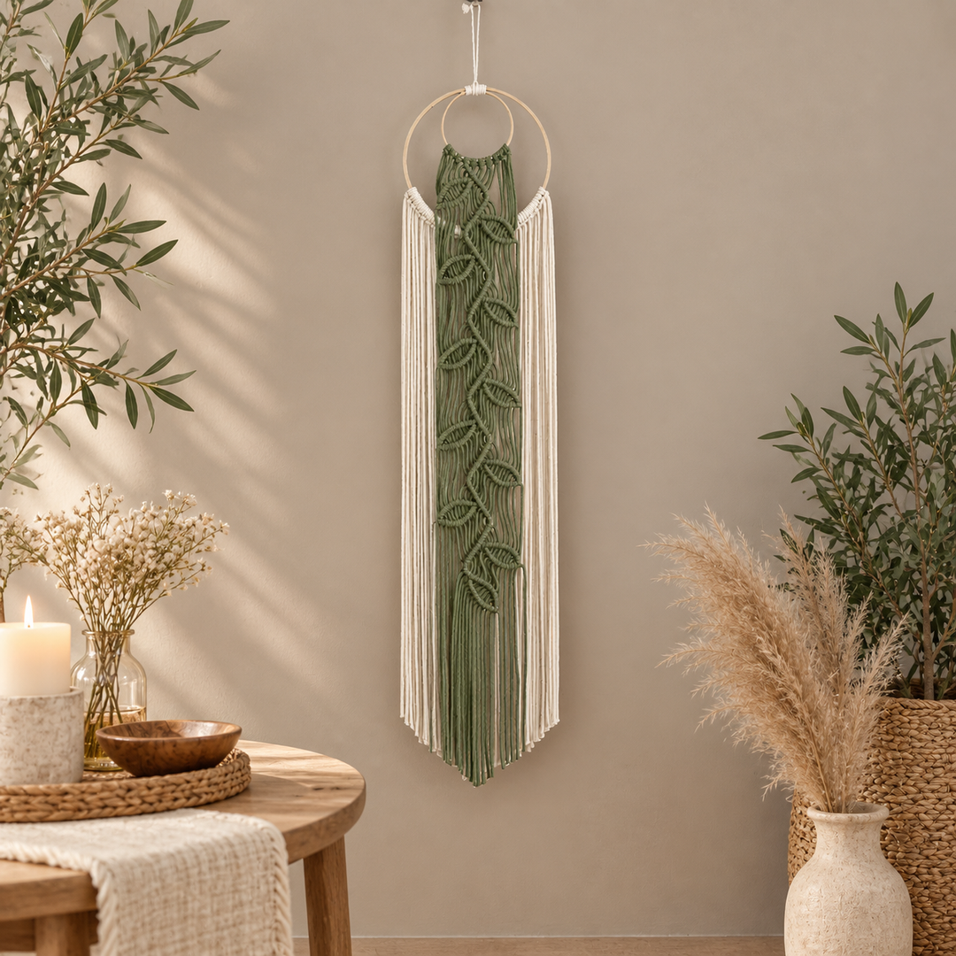 Narrow leaf vine wall hanging beside a round table with candles and pampas