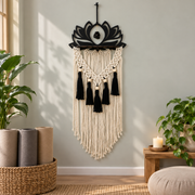 Black lotus macrame hanging above rolled yoga mats in a studio corner