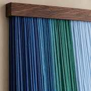 Macro of the blue, teal and pale blue cords meeting the batten