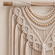 Close view of the wooden bead swags and braided cord on the pale wooden dowel