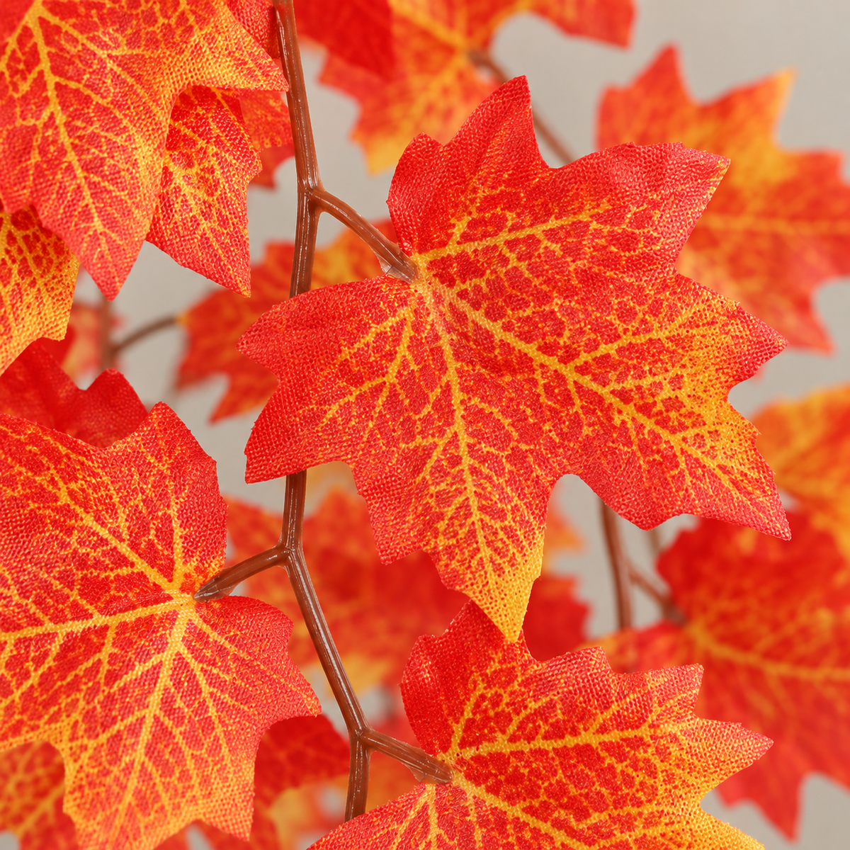 Close view of printed red and gold maple leaves on the wrapped wire vine stem