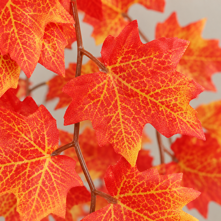 Close view of printed red and gold maple leaves on the wrapped wire vine stem