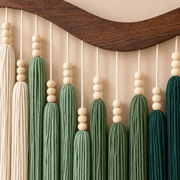 Close view of beaded cords and green combed tassels under the curved wood