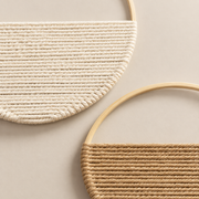 Macro of the cream and tan wound faces meeting their rings, set of 2 woven half moon hoops, 19 cm
