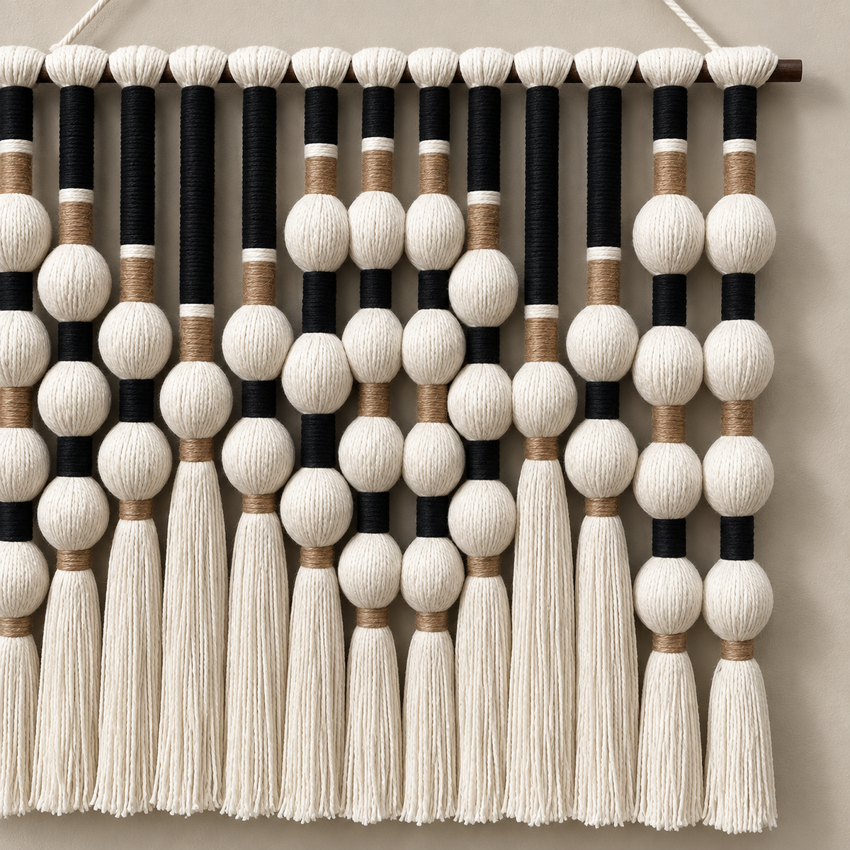 Macro of the black columns, cream spheres and tan collars, bead grid and tassels