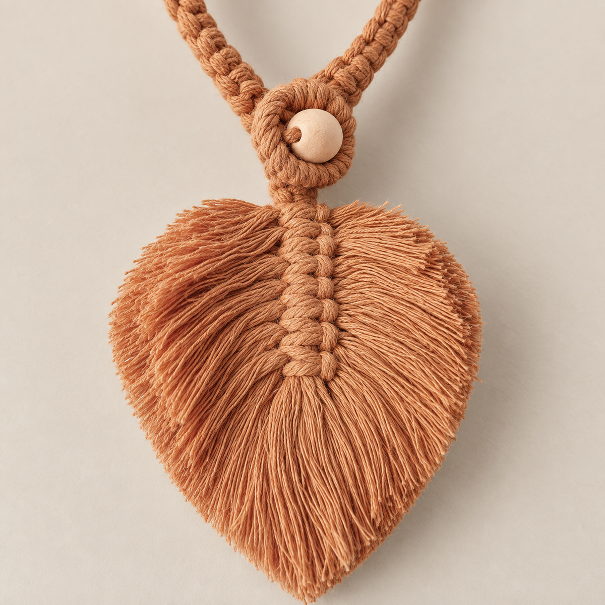 Macro of the brown leaf, its knot spine and the wooden bead, macrame leaf holdbacks in 6 colors