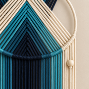 Close view of blue chevron winding over the wooden hoop with a pale bead