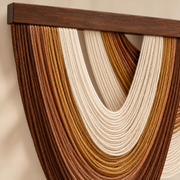 Close view of rust and mustard cord bands looping under the dark wood batten