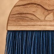 Close view of wavy wood grain meeting the fine indigo cord fringe below it
