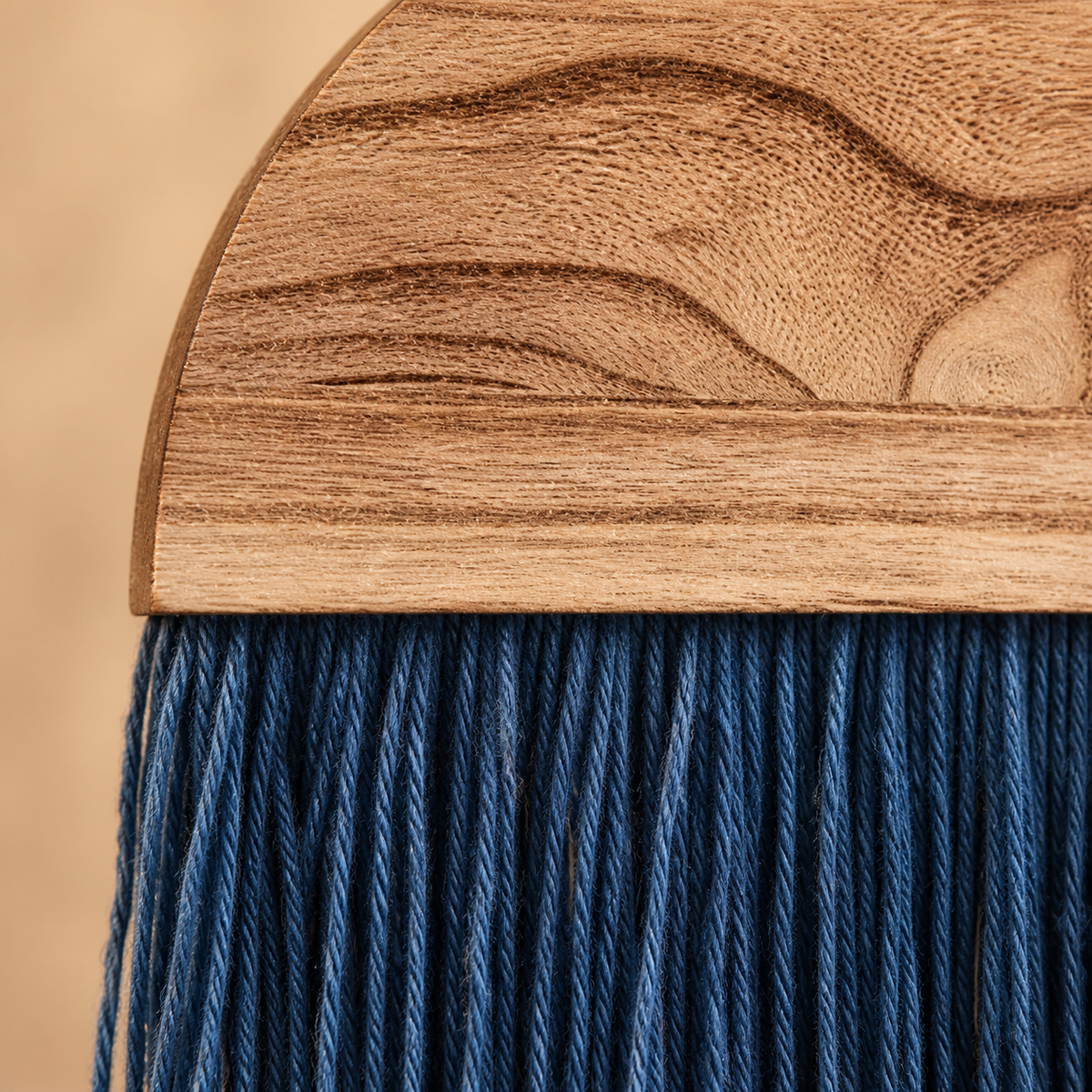 Close view of wavy wood grain meeting the fine indigo cord fringe below it