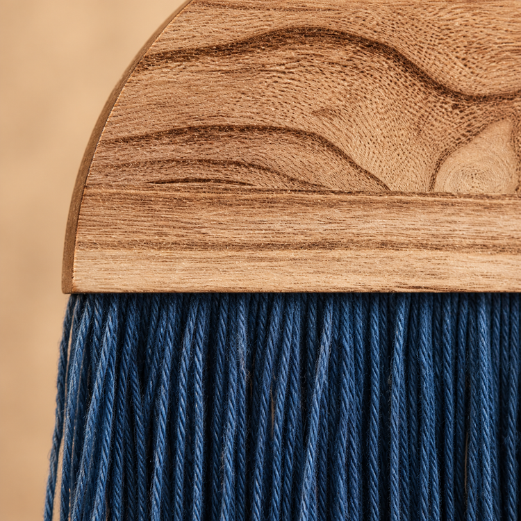 Close view of wavy wood grain meeting the fine indigo cord fringe below it