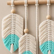 Close view of turquoise dipped feather tips, knotted spines and a wooden bead