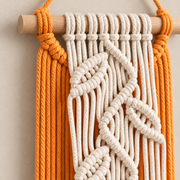 Close view of cream knotted leaves over orange cord at the wrapped dowel end