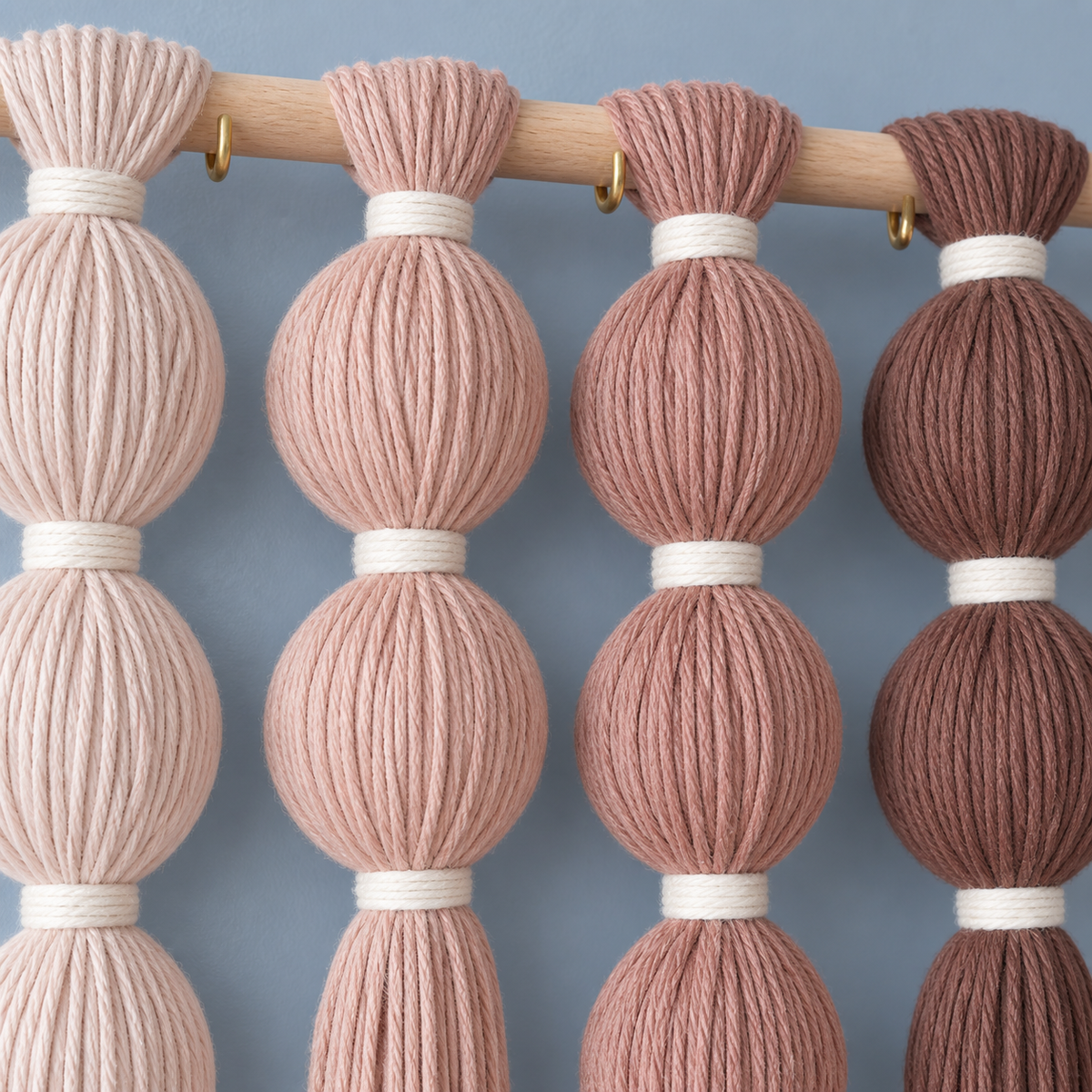 Macro of four spheres and their white bindings, wrapped sphere grid in blush