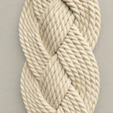 A close-up of thick, braided rope in a warm off-white or cream color, arranged in a twisted loop against a plain light gray background.