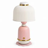 A decorative table lamp with a ribbed white dome shade, a pink ribbed base, and gold metallic accents, shown on a plain white background.