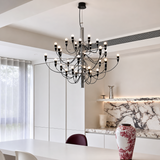 Modern chandelier hanging in a room with a vase and marble surface.