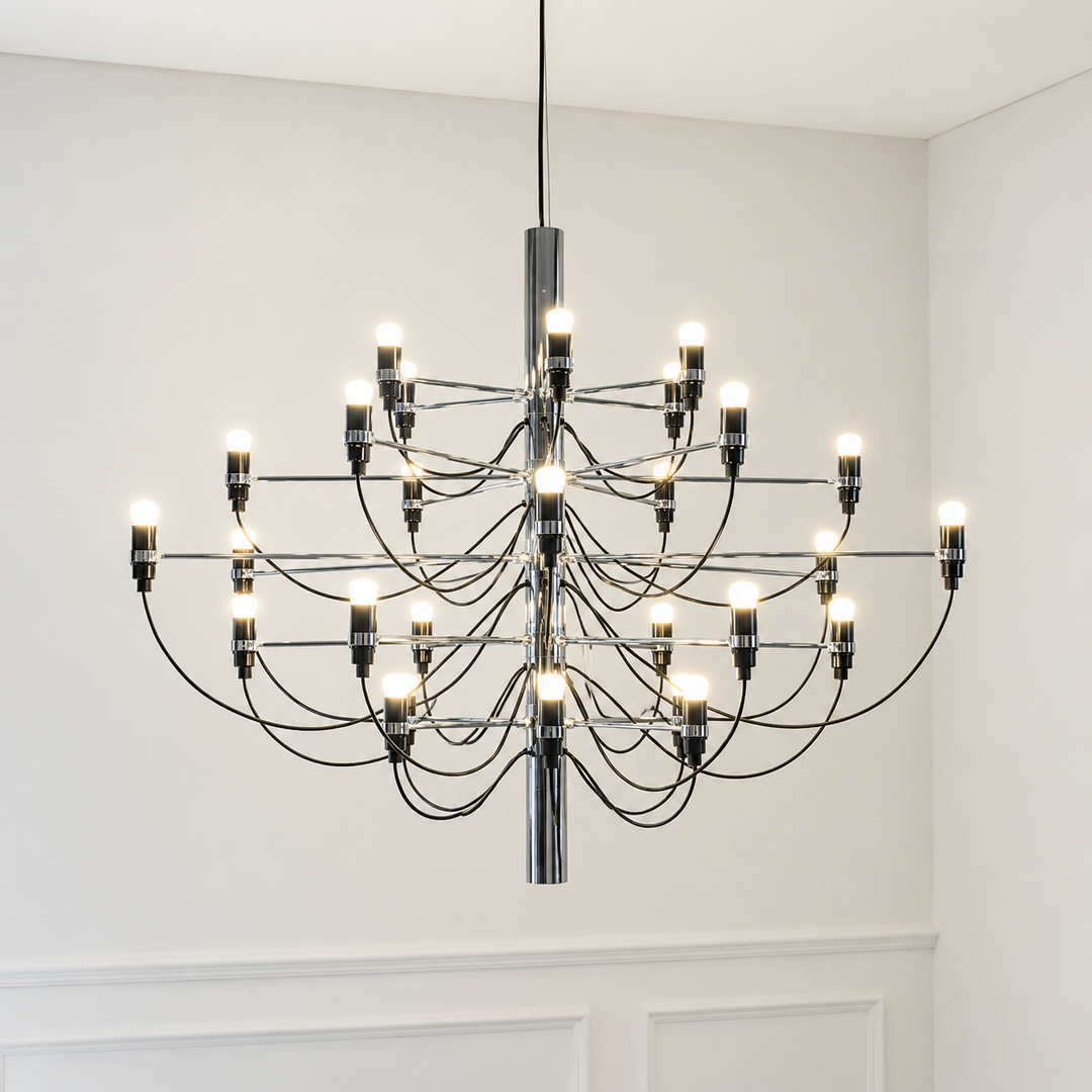 Modern chandelier hanging in a room with white walls and a white door.