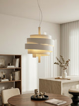 Modern pendant light hanging above a dining table in a well-lit room.
