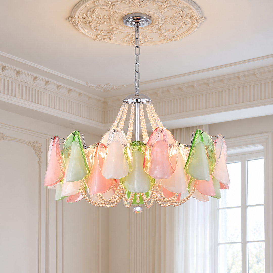 A hanging chandelier with translucent flower-shaped shades in pastel pink, peach, and mint green, suspended by a chain in an ornate cream-colored room with a decorative ceiling medallion and window.