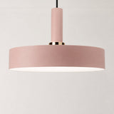 A modern pendant light with a wide, shallow drum shade in a dusty pink color, a matching cylindrical neck, and a polished gold accent ring, suspended against a clean white background.