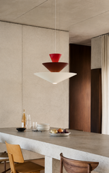 Modern kitchen with pendant lights, concrete countertop, and wooden chairs.