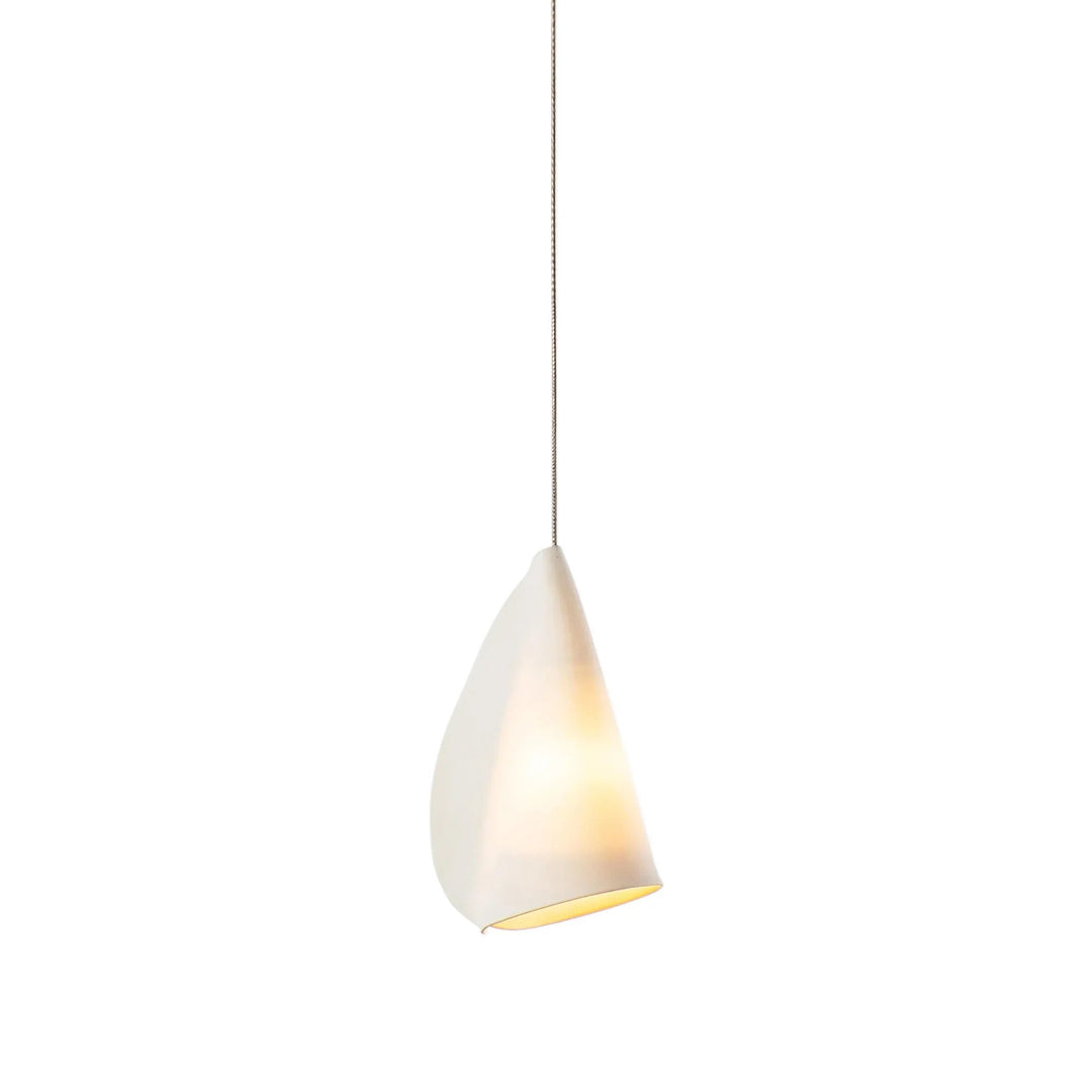 Chandelier detail showing a single folded white porcelain shade glowing softly against a white background.
