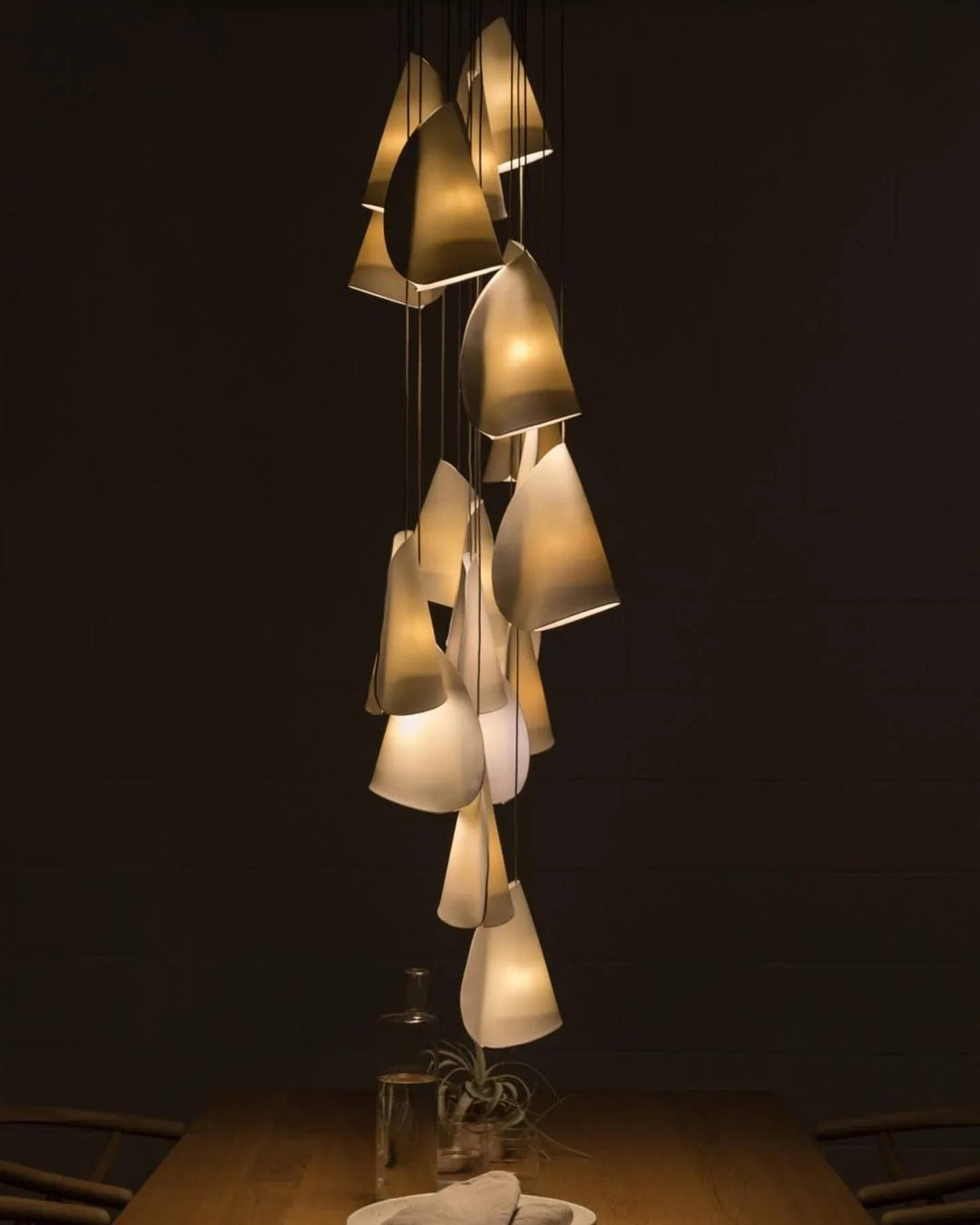 Modern chandelier with multiple lampshades on a dark background