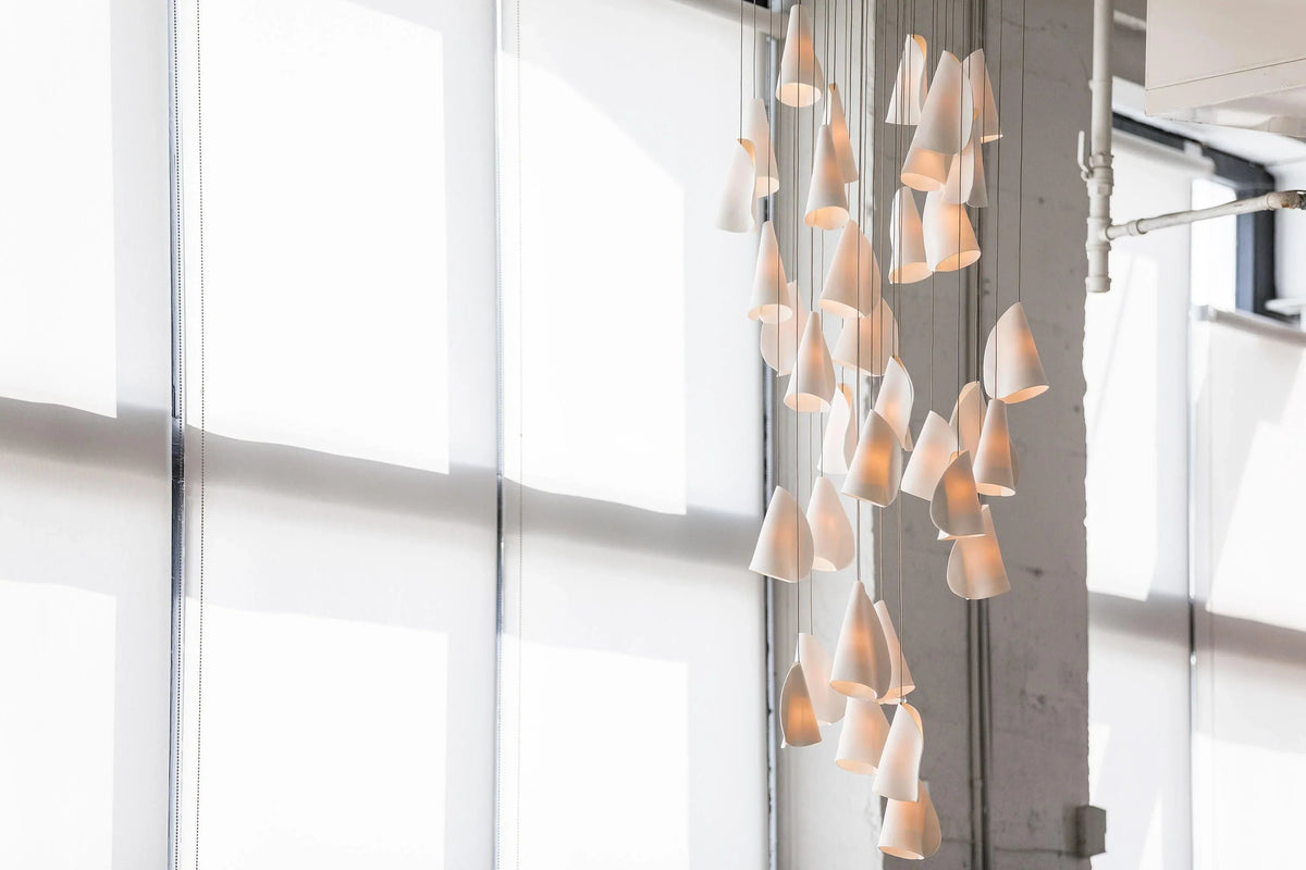 Modern chandelier hanging in a room with large windows