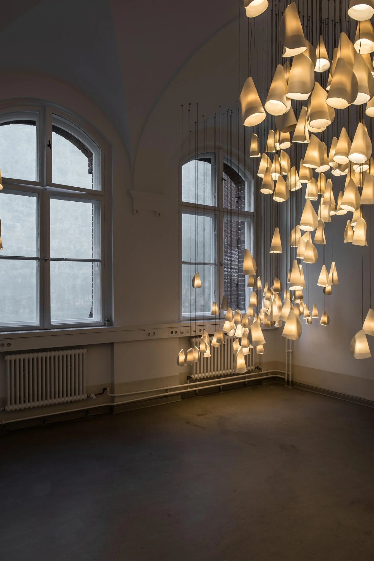 Large chandelier hanging in a room with large windows