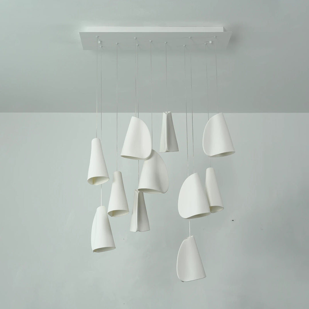 White porcelain chandelier with folded shades suspended at varied heights from a rectangular ceiling canopy, viewed from the front.