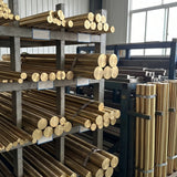 Bundles of brass rods stacked horizontally and vertically on workshop racks, with no chandelier visible.
