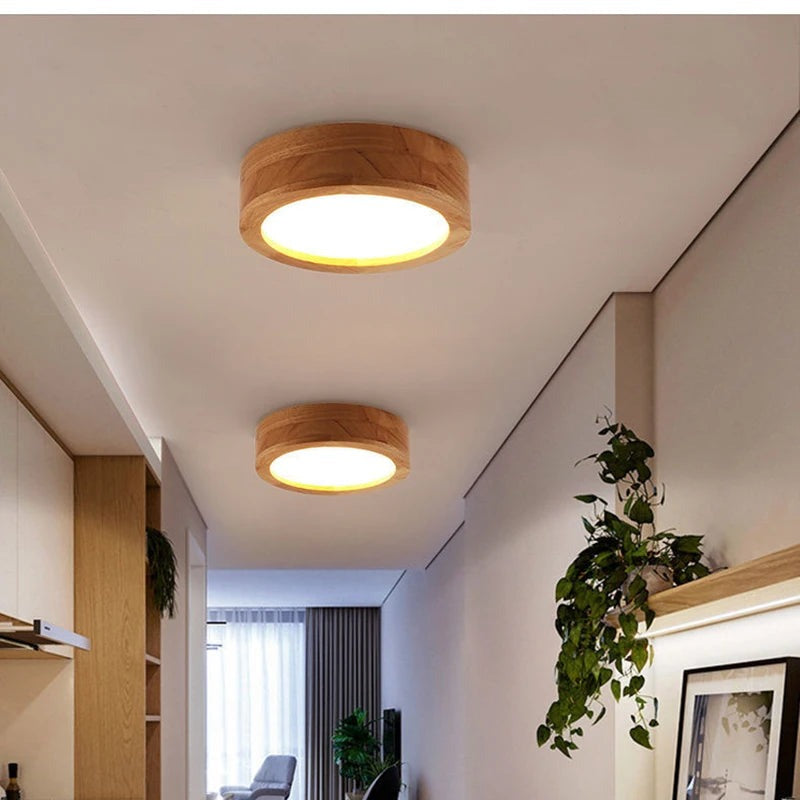 Wood flush mount ceiling light over a warm wood dresser with ceramic fish figurines
