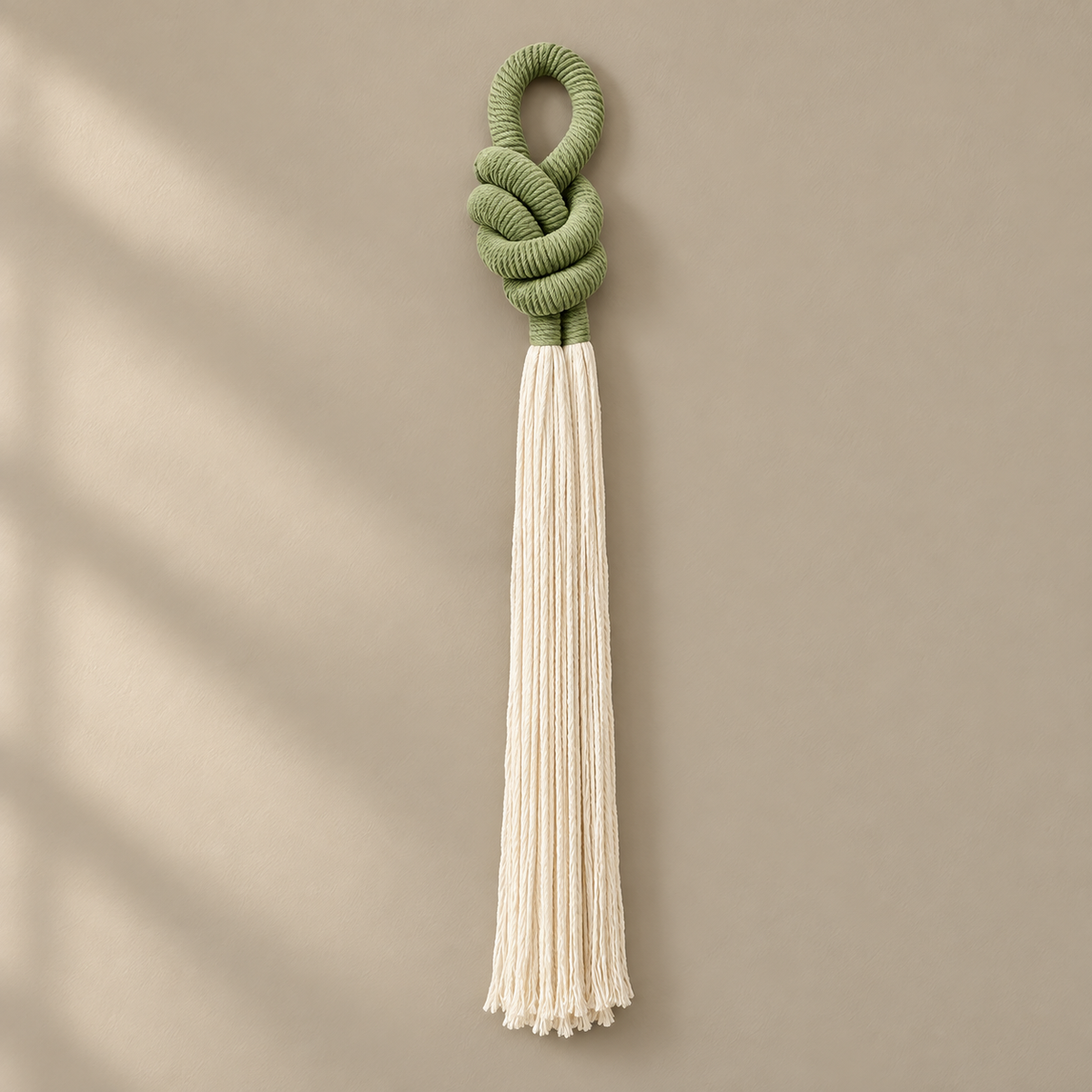 Studio, full piece on cream, rope knot with a cream tassel, thick three-strand twisted rope, fine combed cord tassel
