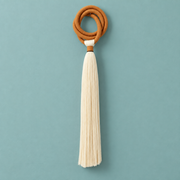 Studio on teal, full piece, terracotta ring and long tassel, wrapped cord ring, fine combed cord tassel