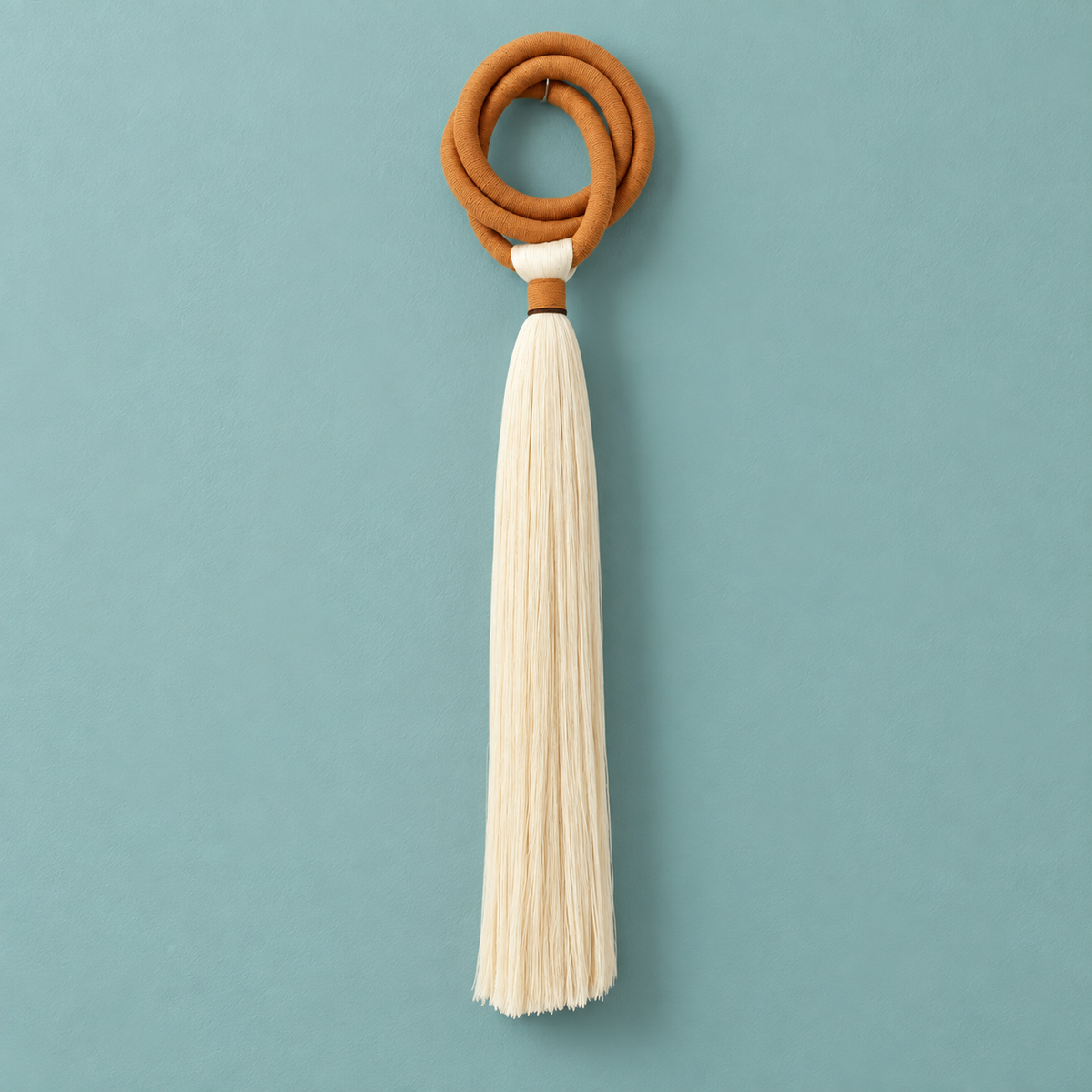 Studio on teal, full piece, terracotta ring and long tassel, wrapped cord ring, fine combed cord tassel
