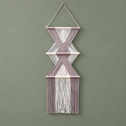 Dusty mauve and cream knotted macrame wall hanging with two diamonds on a sage wall