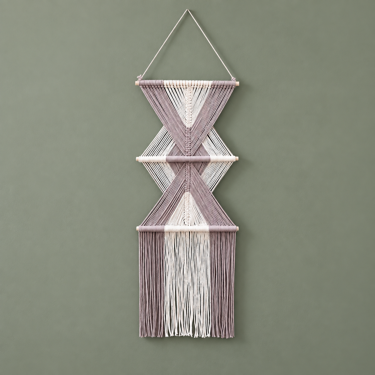 Dusty mauve and cream knotted macrame wall hanging with two diamonds on a sage wall