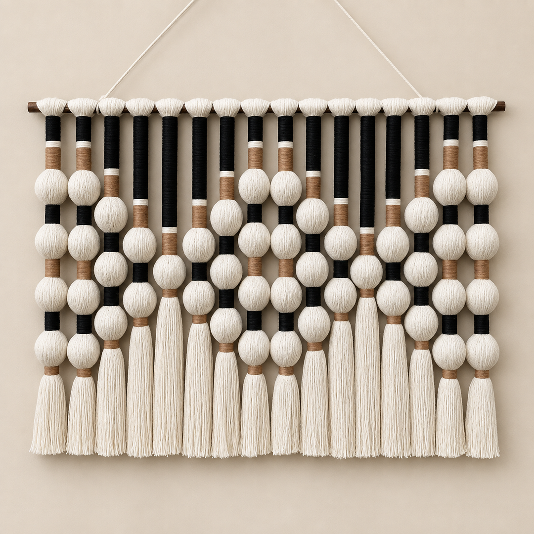 Black studio on cream, bead grid and tassels, yarn-wrapped spheres, wrapped cord